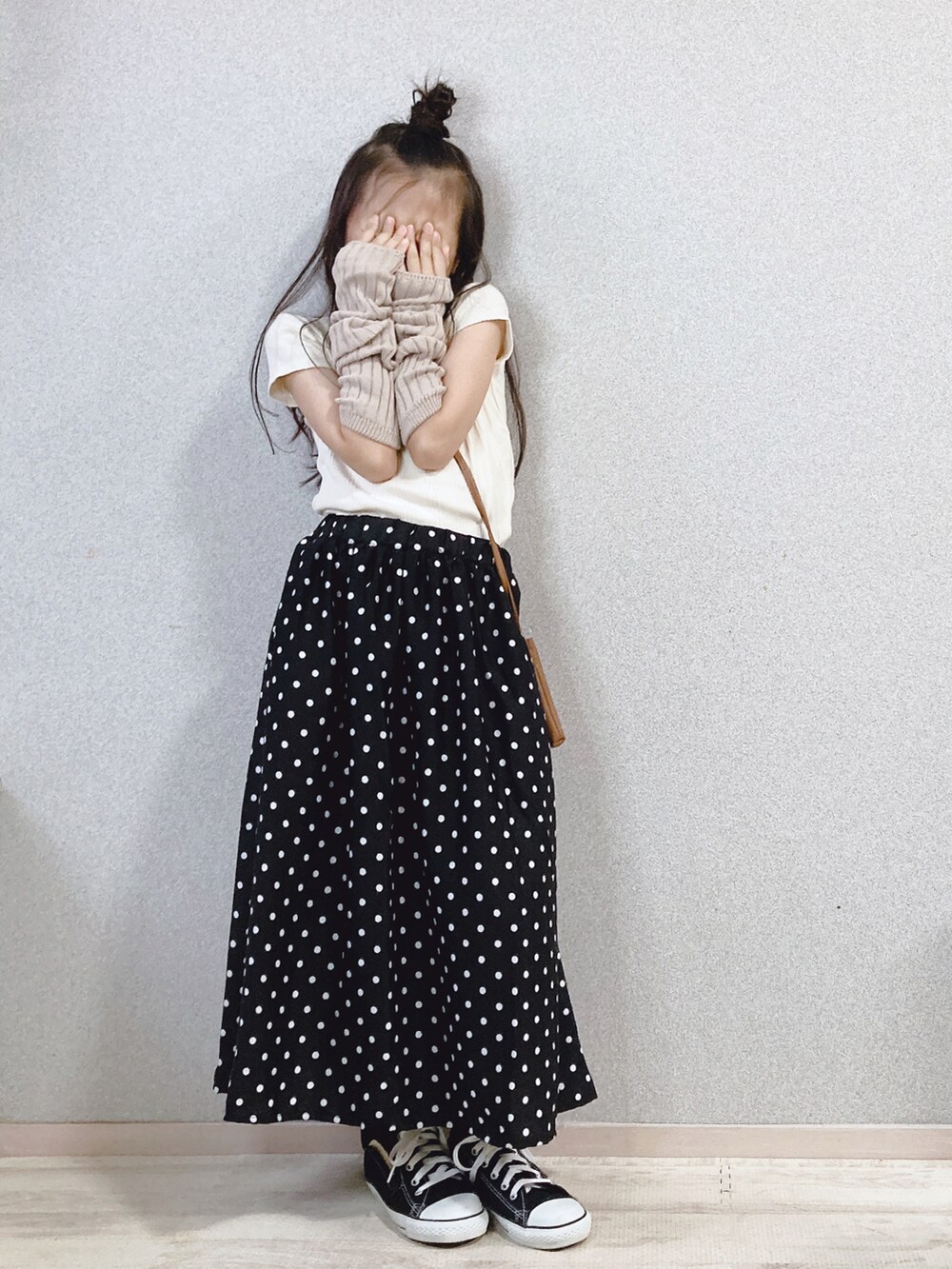 ホワイト系のTシャツ/カットソー、ブラック系のスカート、ブラウン系のショルダーバッグを着用したキッズの秋コーディネートの3枚目の写真