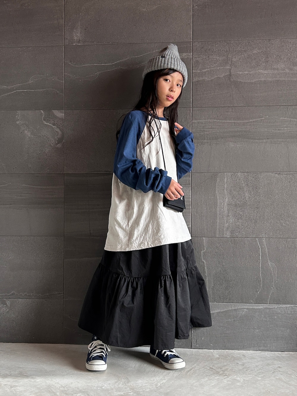 ブラック系のワンピース、ブルー系のスニーカー、ブルー系のTシャツ/カットソーを着用したキッズの秋コーディネートの2枚目の写真