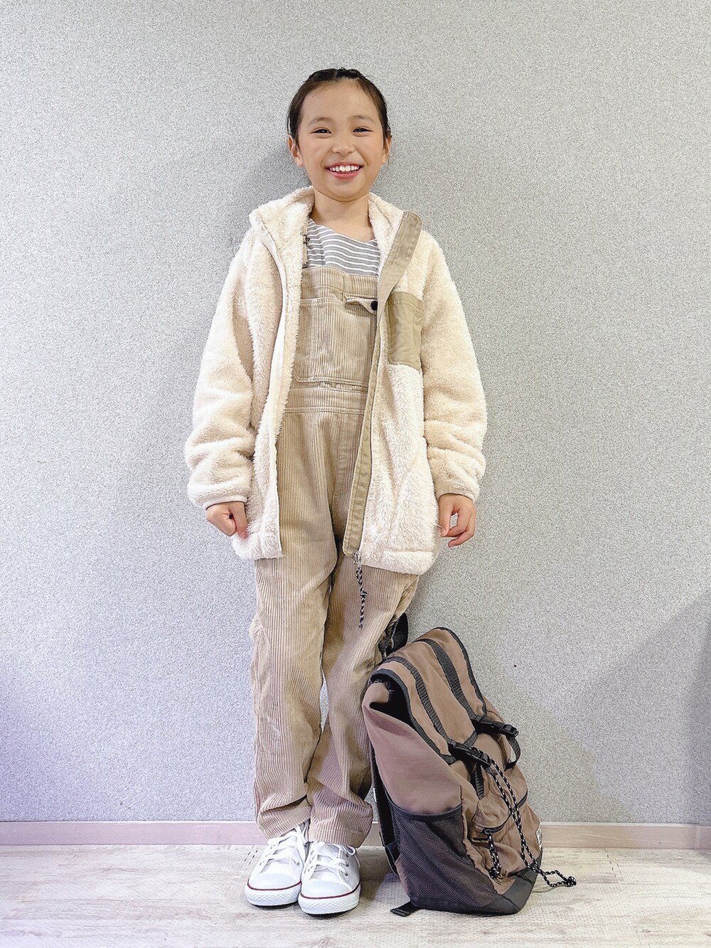 ホワイト系のブルゾン、ベージュ系のサロペット/オーバーオール、グレー系のバックパック/リュックを着用したキッズの秋コーディネートの2枚目の写真