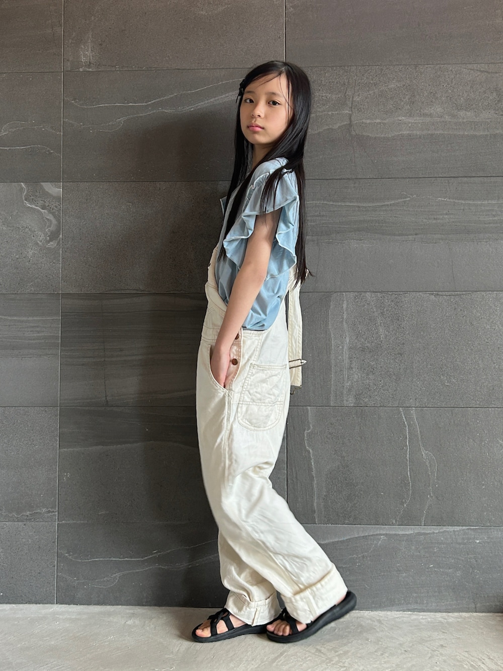 ブルー系のTシャツ/カットソー、ホワイト系のつなぎ/オールインワン、ブラック系のサンダルを着用したキッズの春コーディネートの2枚目の写真