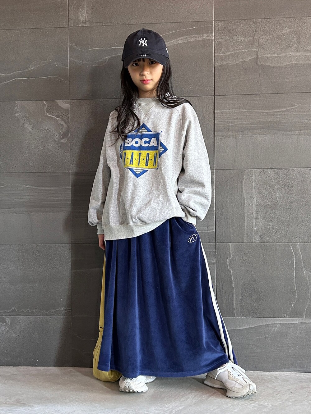 グレー系のスウェット、ブルー系のスカート、ホワイト系のスニーカーを着用したキッズの冬コーディネートの2枚目の写真