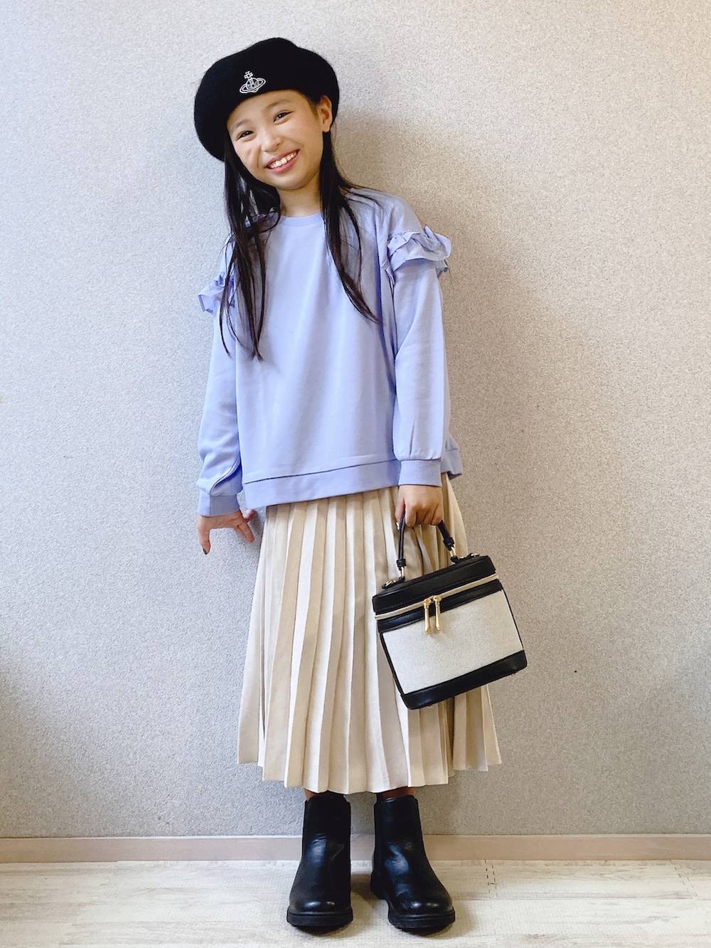 ブルー系のパーカー、ホワイト系のスカート、ブラック系のショルダーバッグを着用したキッズの夏コーディネートの3枚目の写真