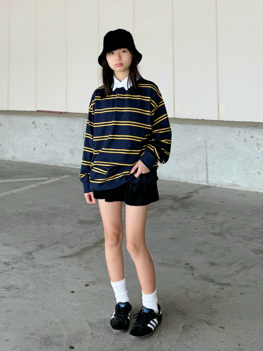 ベージュ系のブルゾン、ブラック系のスニーカー、ブルー系のポロシャツを着用したキッズの秋コーディネートの2枚目の写真