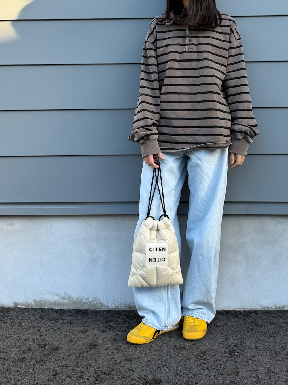 ベージュ系のショルダーバッグ、ブラウン系のTシャツ/カットソー、イエロー系のスニーカーを着用したキッズの秋コーディネートの2枚目の写真