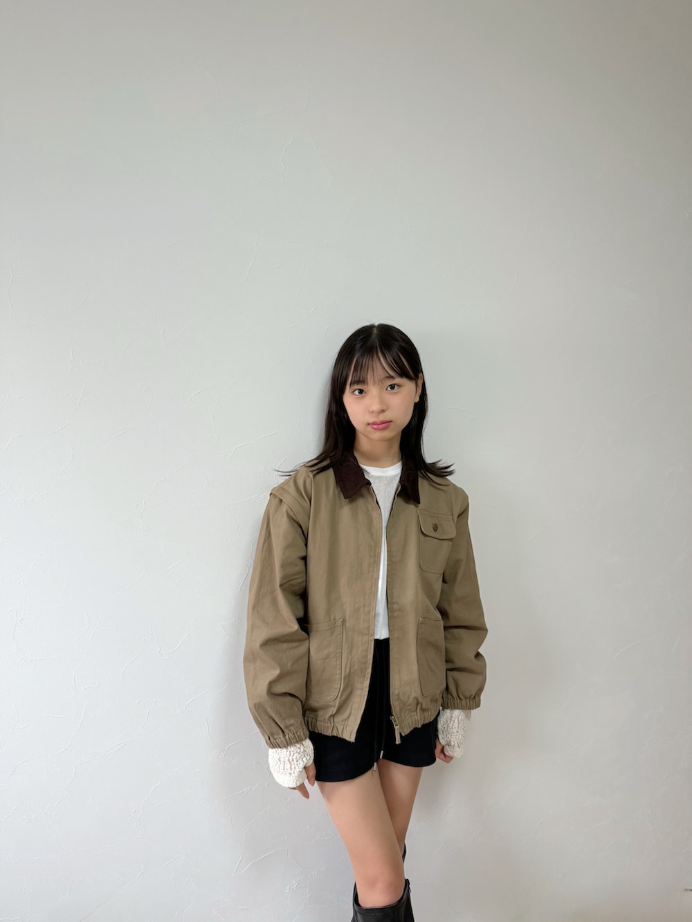 ホワイト系のTシャツ/カットソー、ベージュ系のブルゾン、ブラック系のブーツを着用したキッズの秋コーディネートの3枚目の写真