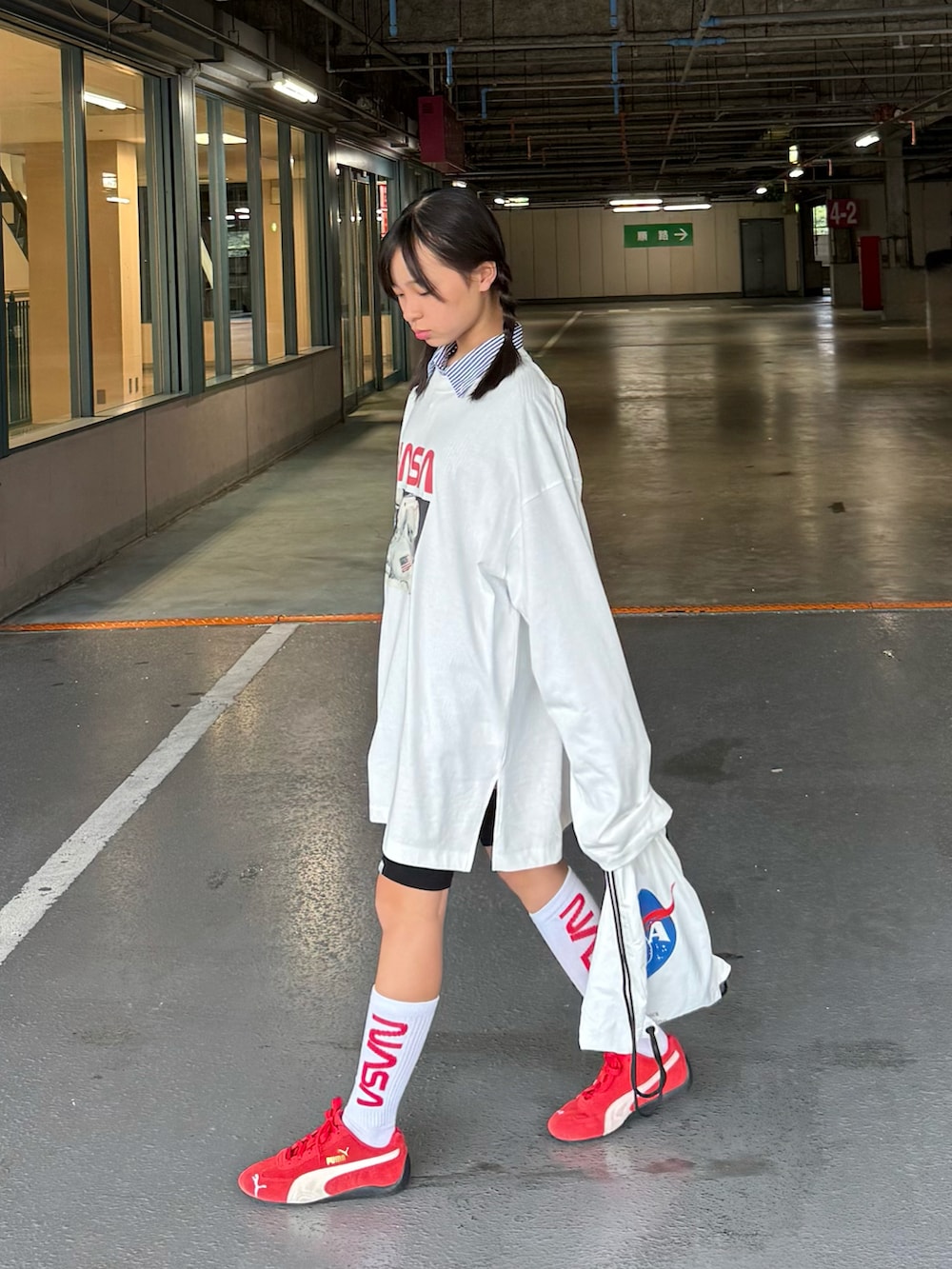 ホワイト系のTシャツ/カットソー、ホワイト系のバックパック/リュック、レッド系のスニーカーを着用したキッズの秋コーディネートの3枚目の写真