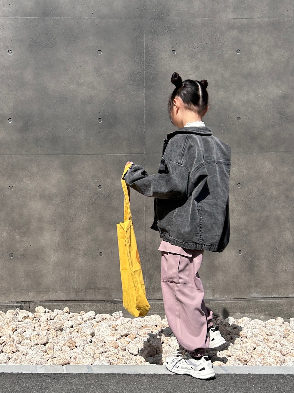 ブラック系のテーラードジャケット、グリーン系のカーゴパンツ、イエロー系のトートバッグを着用したキッズの春コーディネートの4枚目の写真