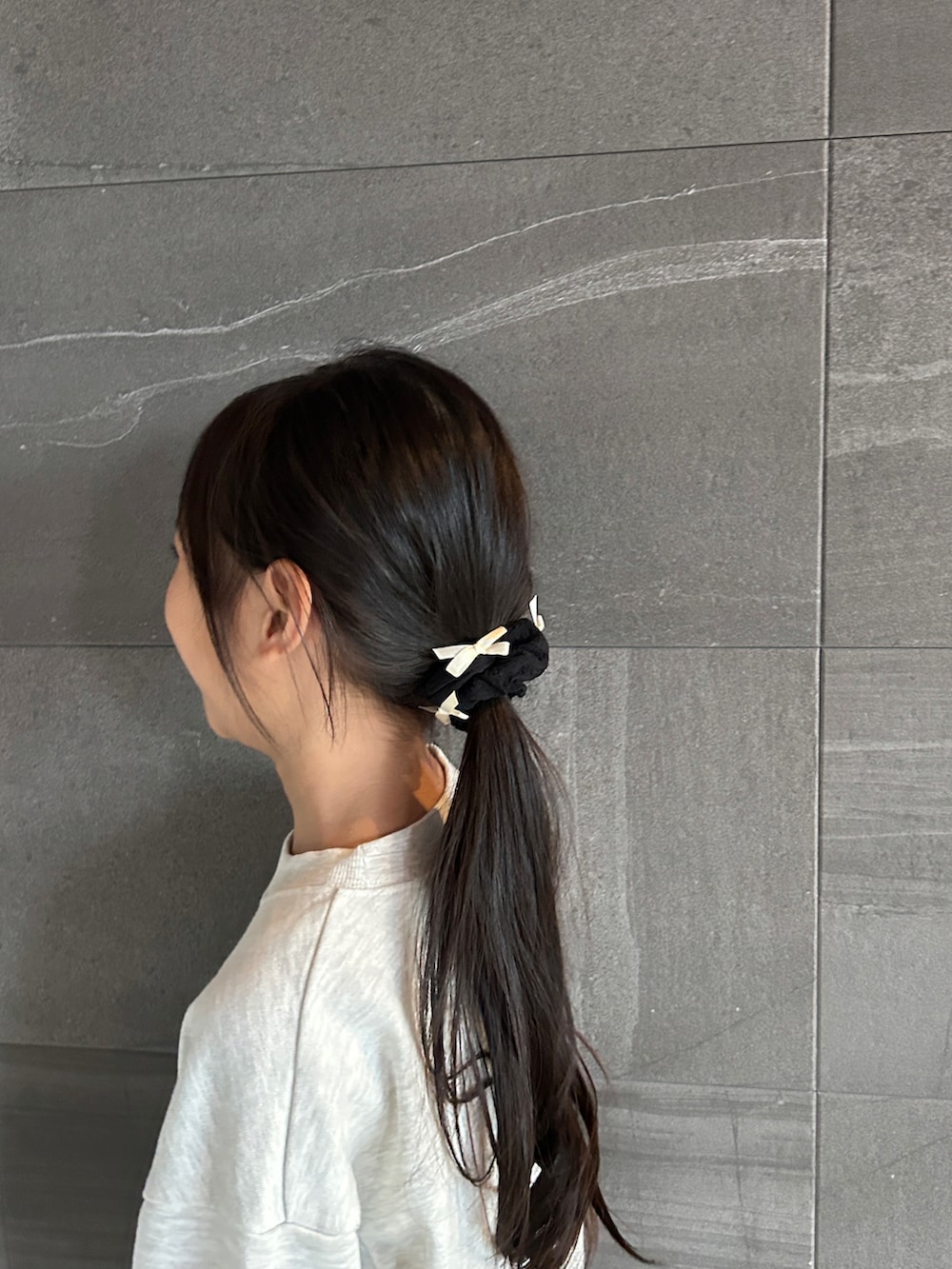 ベージュ系のスウェット、ブルー系のその他パンツ、ブラック系のその他ヘアアクセサリーを着用したキッズの秋コーディネートの4枚目の写真