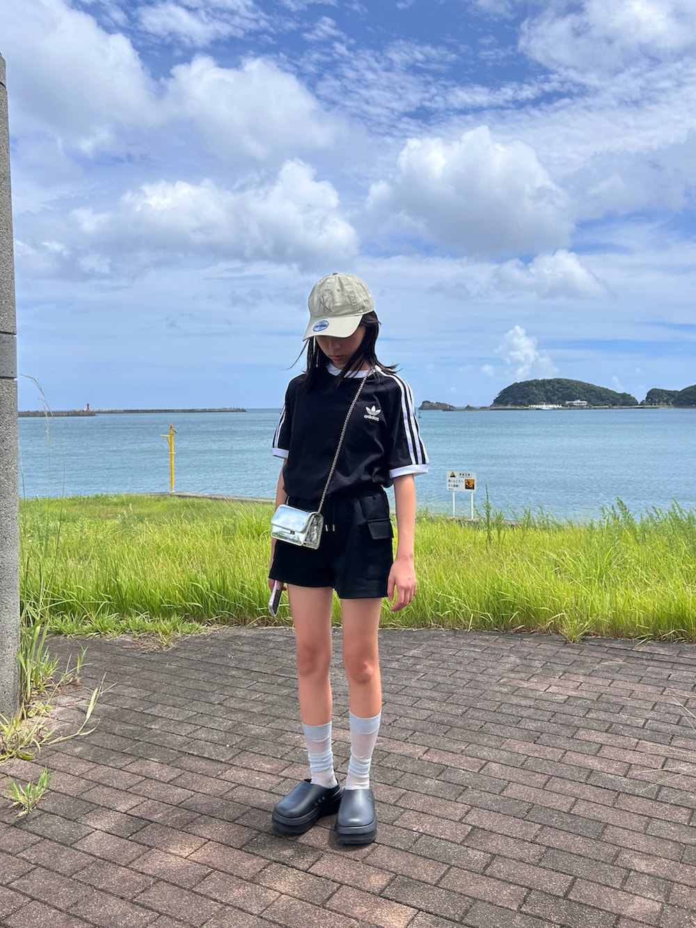 ブラック系のTシャツ/カットソー、ブラック系のサンダル、ベージュ系のキャップを着用したキッズの夏コーディネートの2枚目の写真