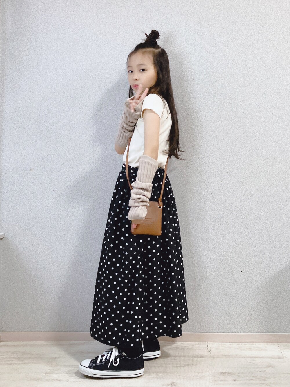 ホワイト系のTシャツ/カットソー、ブラック系のスカート、ブラウン系のショルダーバッグを着用したキッズの秋コーディネートの2枚目の写真