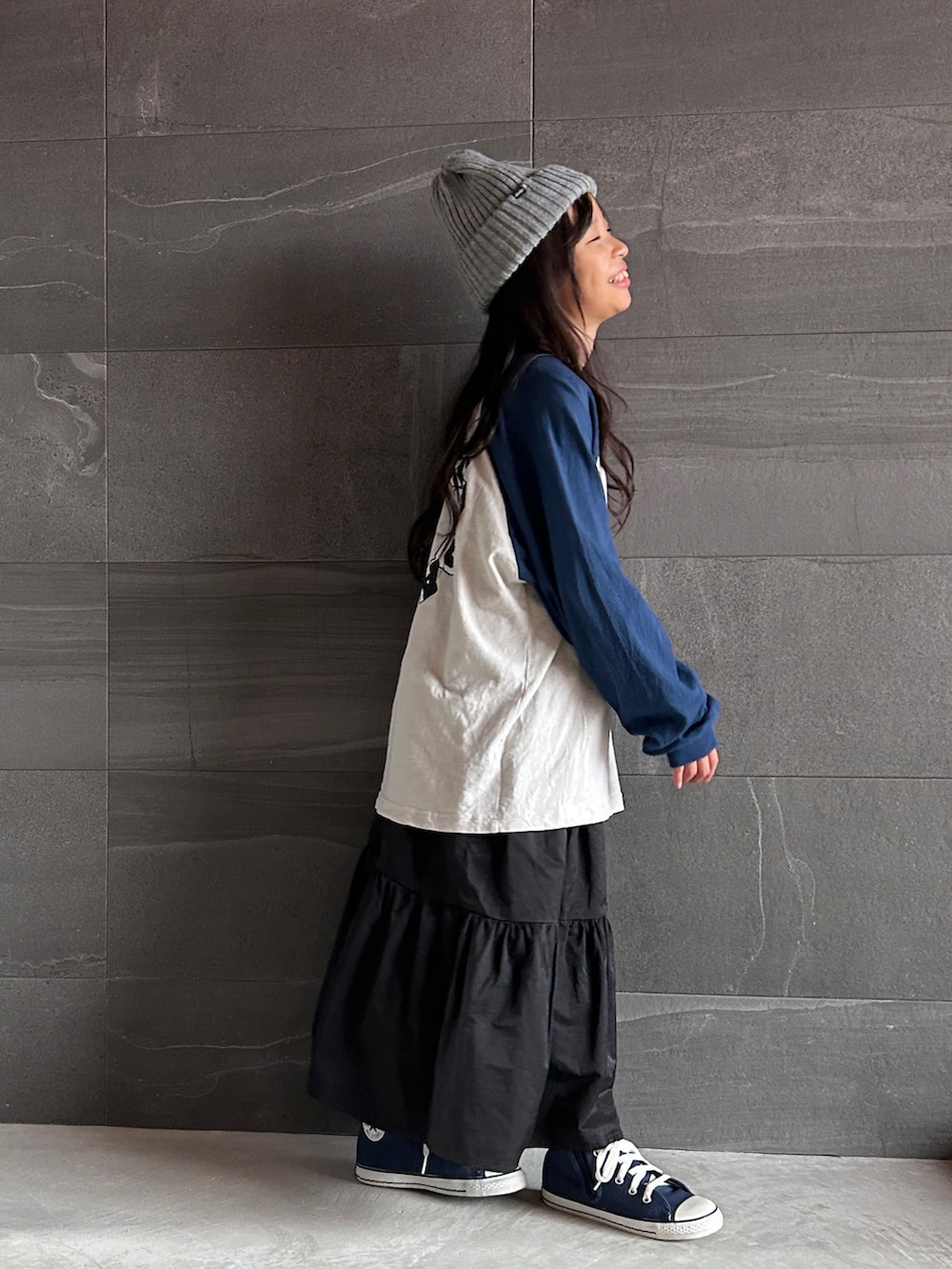 ブラック系のワンピース、ブルー系のスニーカー、ブルー系のTシャツ/カットソーを着用したキッズの秋コーディネートの3枚目の写真