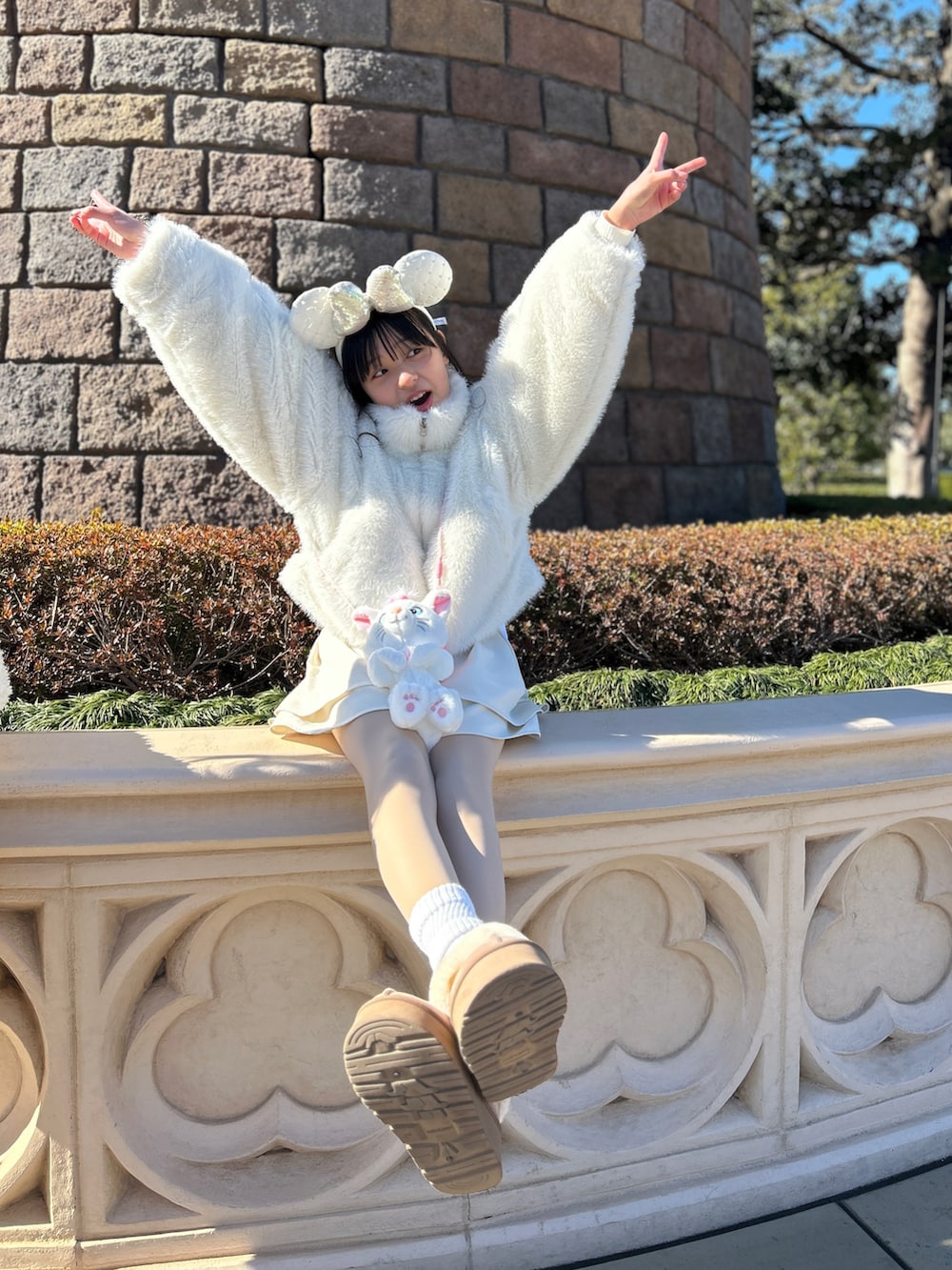 ホワイト系のブルゾン、ホワイト系のスカート、ベージュ系のブーツを着用したキッズの冬コーディネートの2枚目の写真