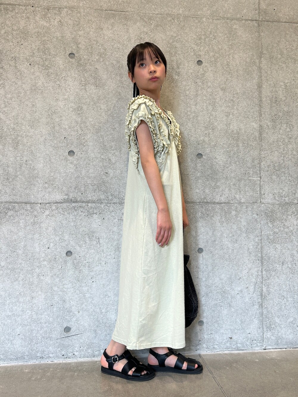 ホワイト系のワンピース、ブラック系のその他トップス、ブラック系のサンダルを着用したキッズの夏コーディネートの3枚目の写真