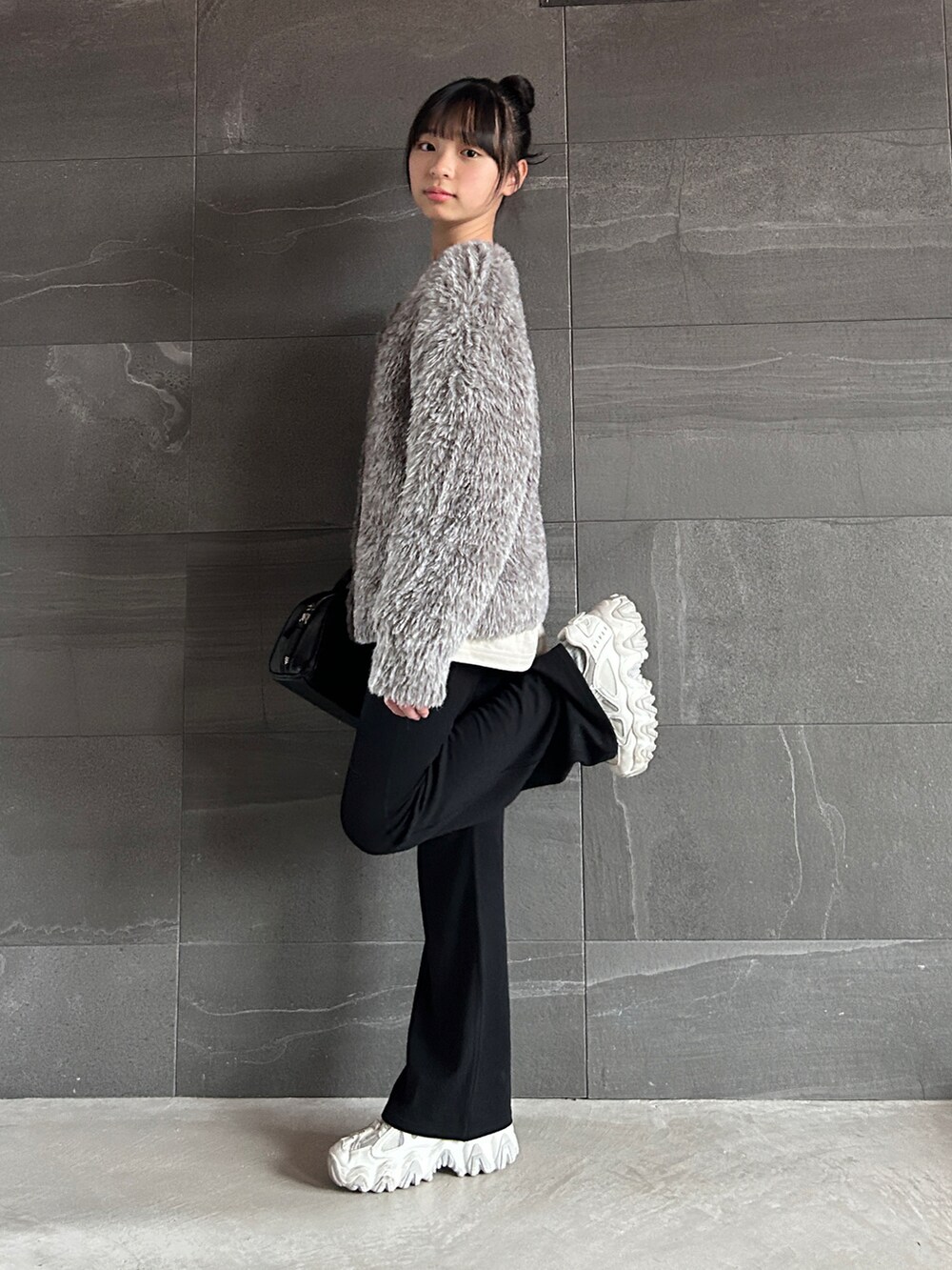 ブラウン系のカーディガン/ボレロ、ベージュ系のTシャツ/カットソー、ブラック系のショルダーバッグを着用したキッズの冬コーディネートの5枚目の写真