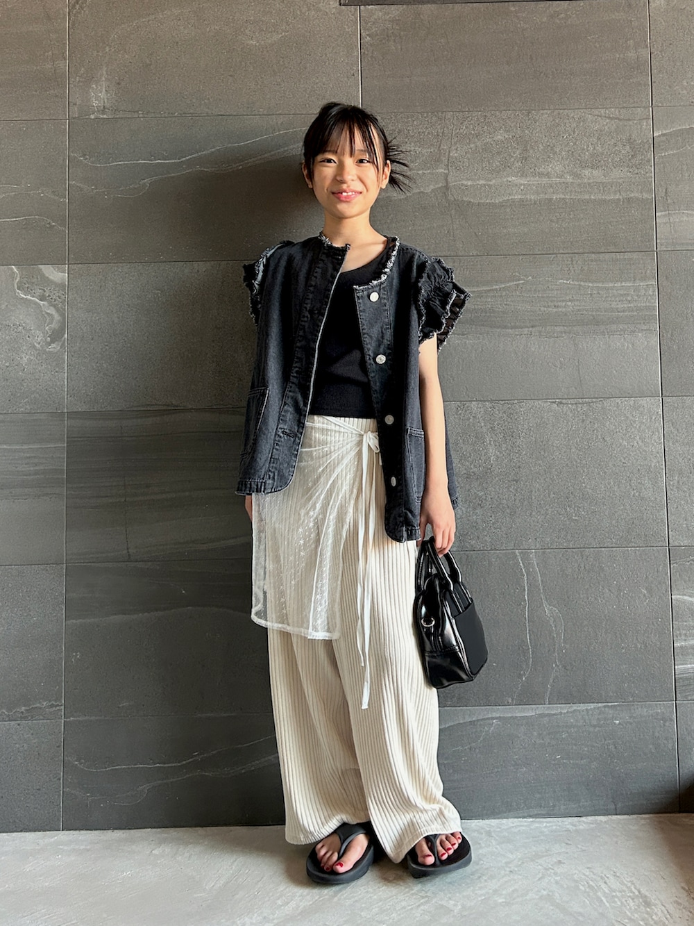 ブラック系のベスト、ホワイト系のその他パンツ、ブラック系のその他トップスを着用したキッズの夏コーディネートの2枚目の写真