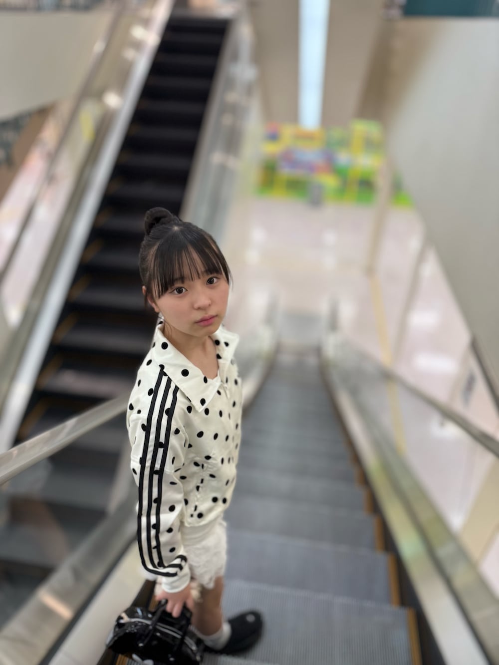 ホワイト系のその他アウター、ホワイト系のその他パンツ、ブラック系のショルダーバッグを着用したキッズの春コーディネートの3枚目の写真