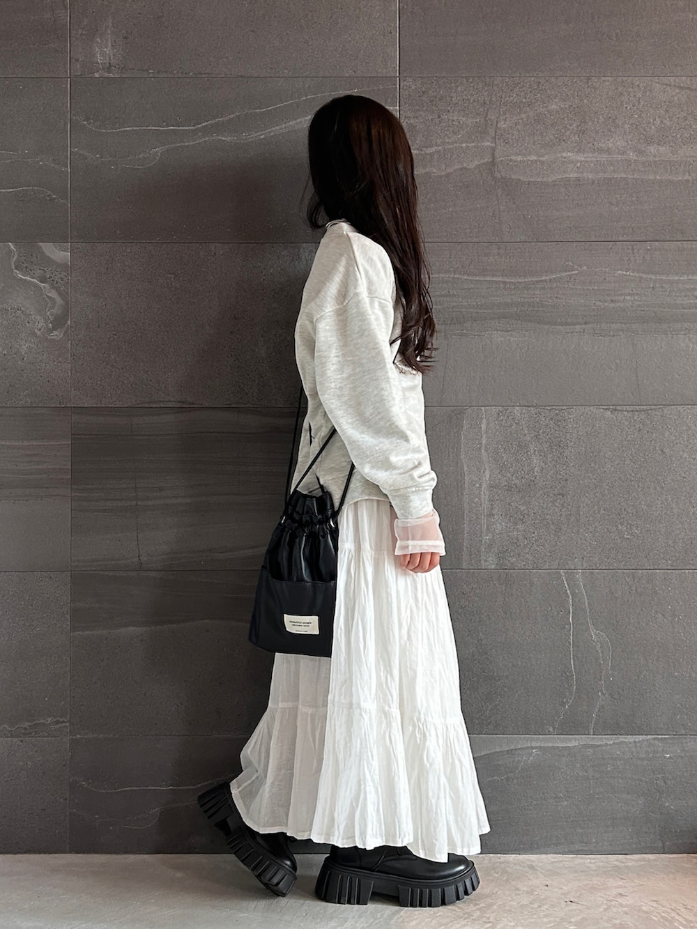 ベージュ系のスウェット、ホワイト系のTシャツ/カットソー、ホワイト系のスカートを着用したキッズの秋コーディネートの2枚目の写真