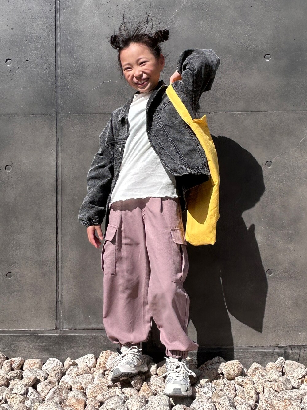 ブラック系のテーラードジャケット、グリーン系のカーゴパンツ、イエロー系のトートバッグを着用したキッズの春コーディネートの3枚目の写真