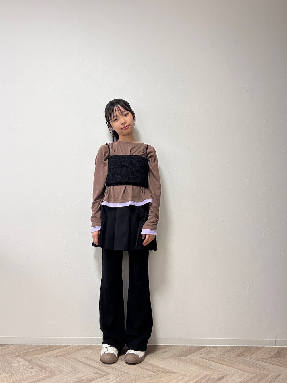 ブラウン系のTシャツ/カットソー、ブラック系のスカート、ベージュ系のスニーカーを着用したキッズの秋コーディネートの3枚目の写真