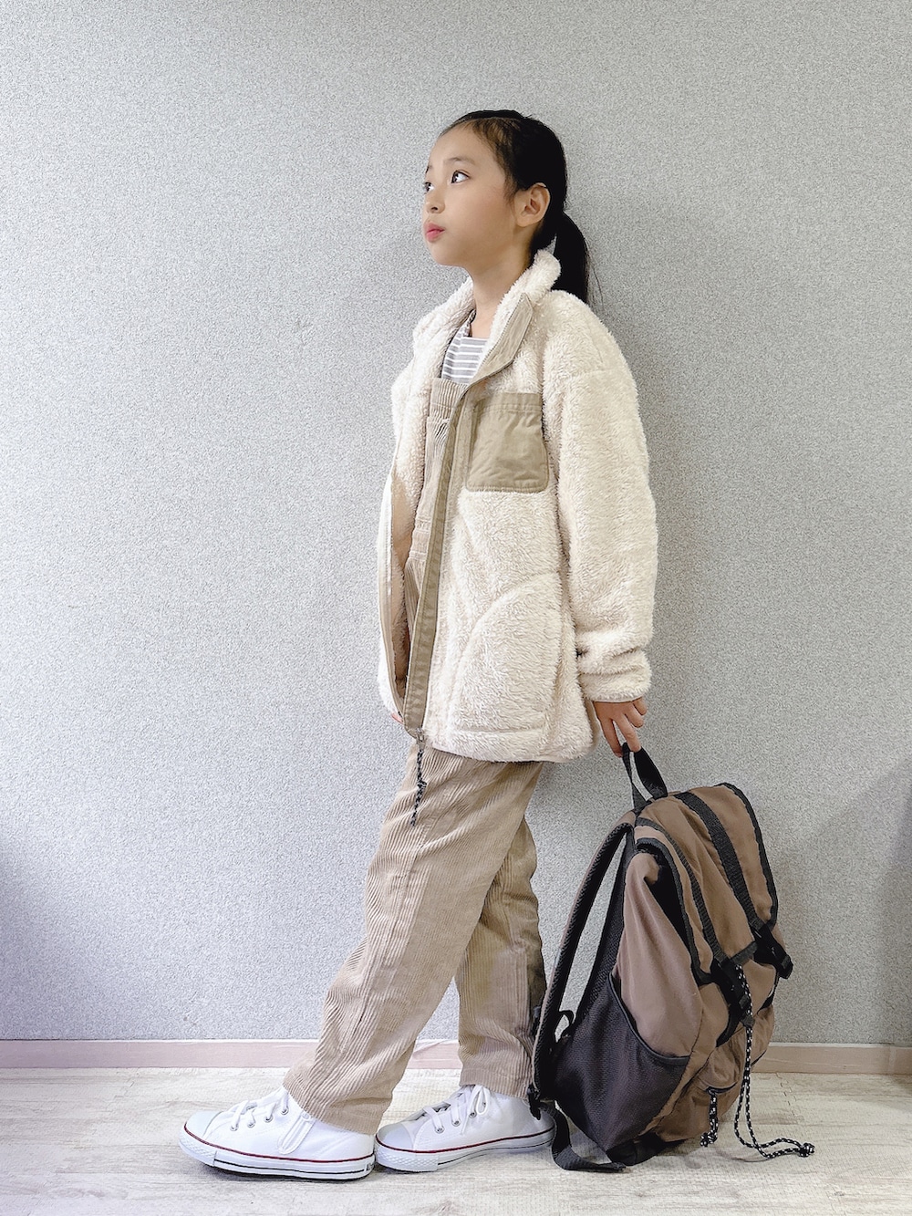 ホワイト系のブルゾン、ベージュ系のサロペット/オーバーオール、グレー系のバックパック/リュックを着用したキッズの秋コーディネートの3枚目の写真