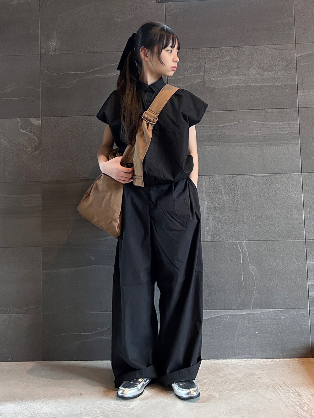 ブラック系のシャツ/ブラウス、ブラック系のパンツ、ブラウン系のショルダーバッグを着用したキッズの春コーディネートの2枚目の写真