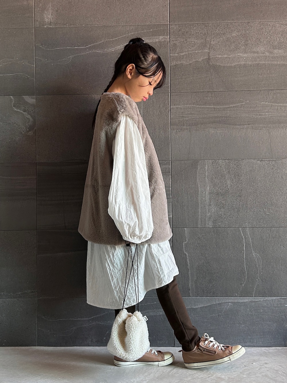 グレー系のベスト、ブラウン系のスウェットパンツ、ホワイト系のワンピースを着用したキッズの秋コーディネートの4枚目の写真