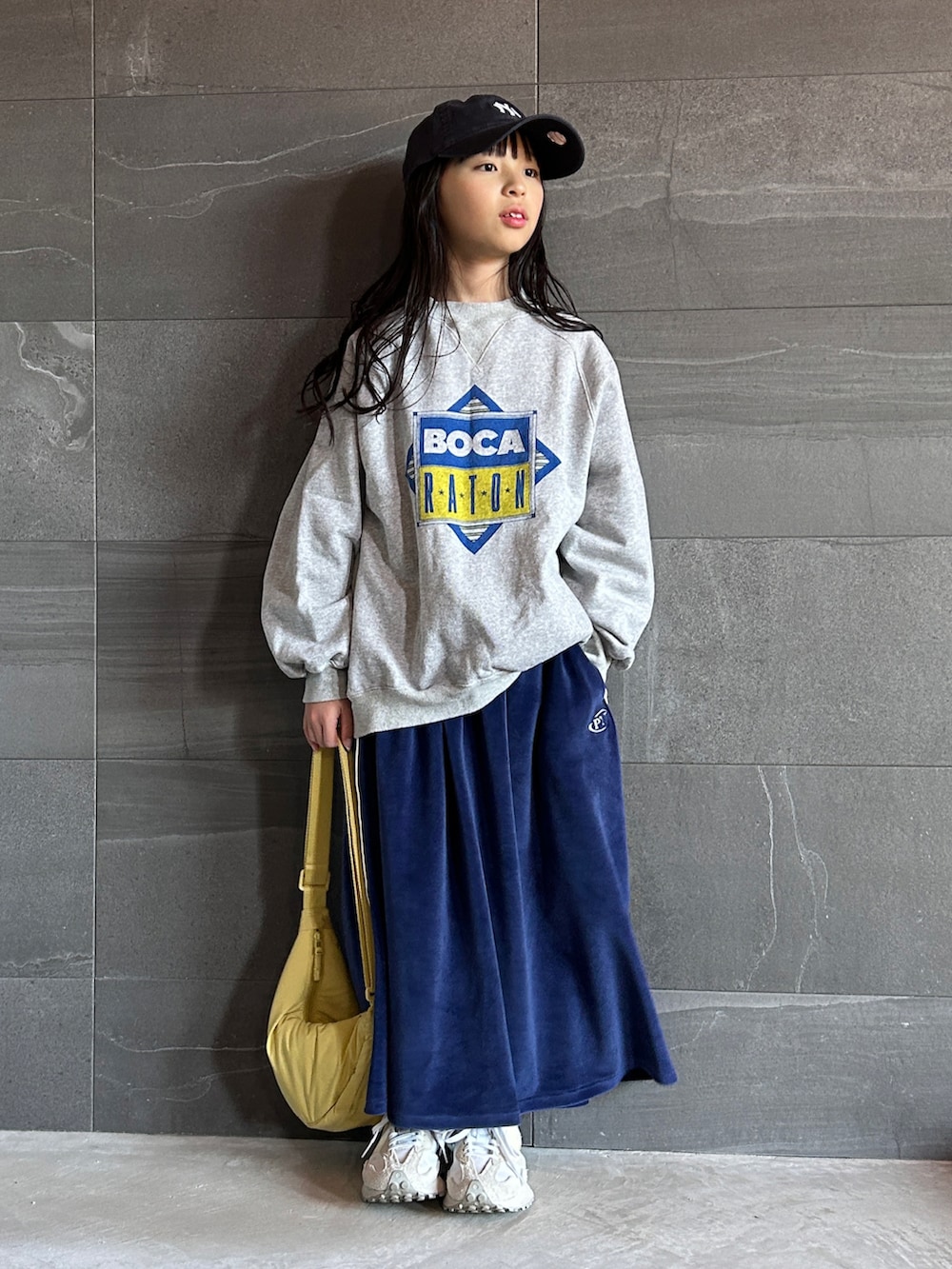 グレー系のスウェット、ブルー系のスカート、ホワイト系のスニーカーを着用したキッズの冬コーディネートの4枚目の写真