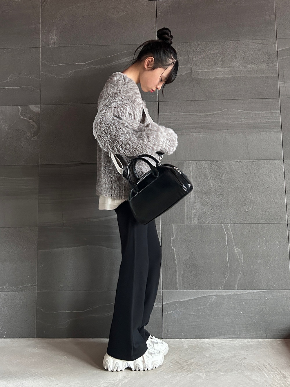 ブラウン系のカーディガン/ボレロ、ベージュ系のTシャツ/カットソー、ブラック系のショルダーバッグを着用したキッズの冬コーディネートの3枚目の写真