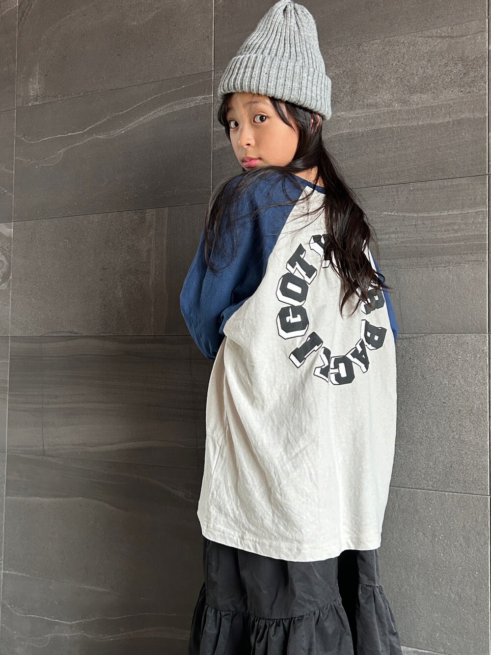 ブラック系のワンピース、ブルー系のスニーカー、ブルー系のTシャツ/カットソーを着用したキッズの秋コーディネートの5枚目の写真