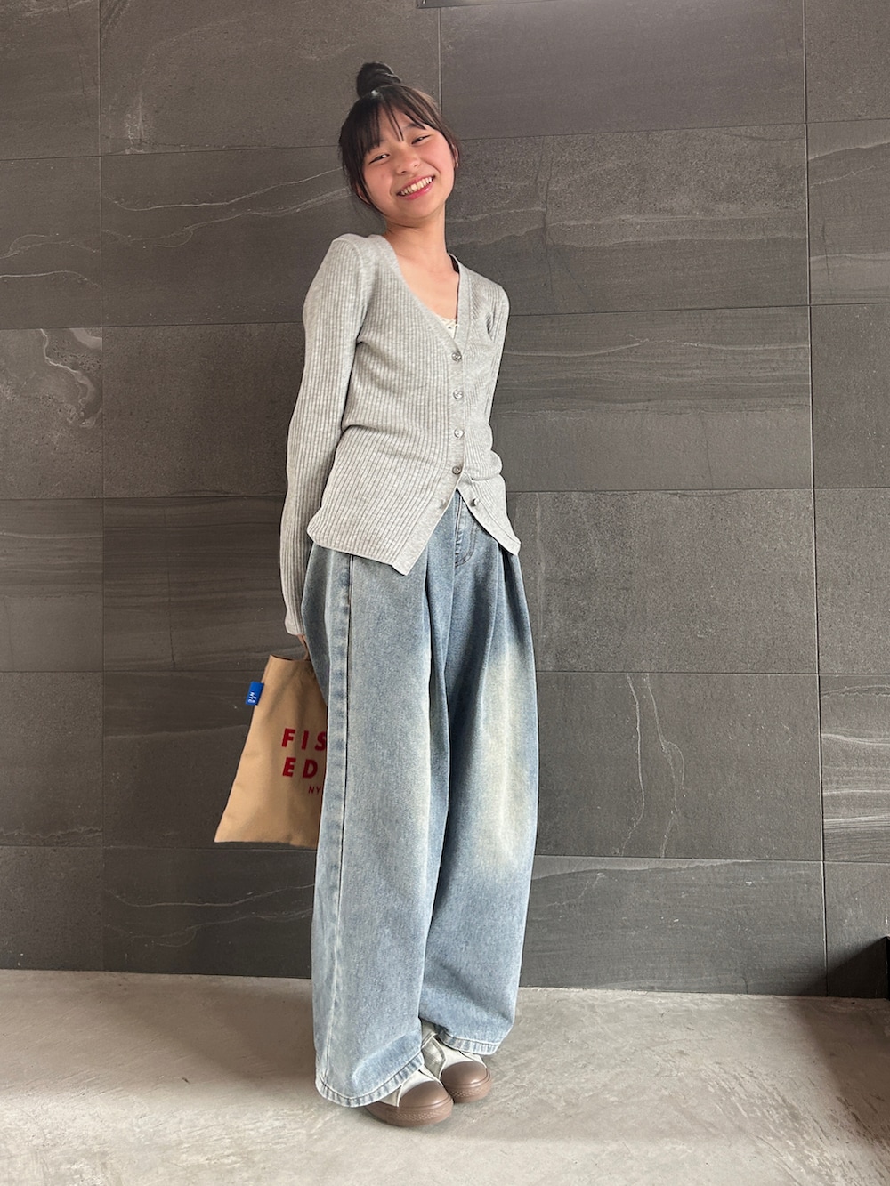 グレー系のカーディガン/ボレロ、ホワイト系のキャミソール、ブルー系のデニムパンツを着用したキッズの春コーディネートの2枚目の写真