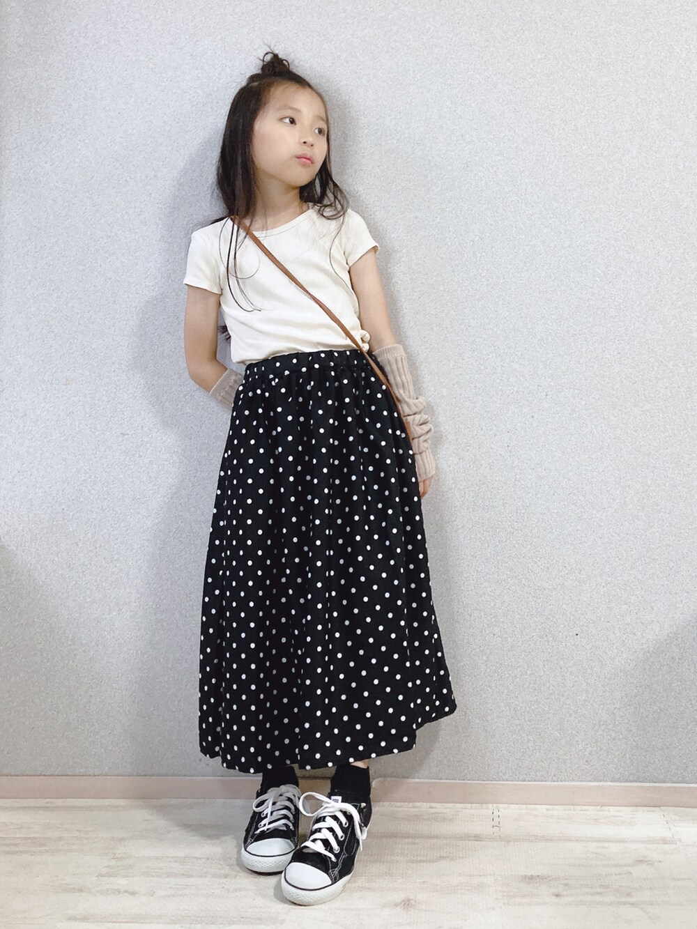 ホワイト系のTシャツ/カットソー、ブラック系のスカート、ブラウン系のショルダーバッグを着用したキッズの秋コーディネートの4枚目の写真