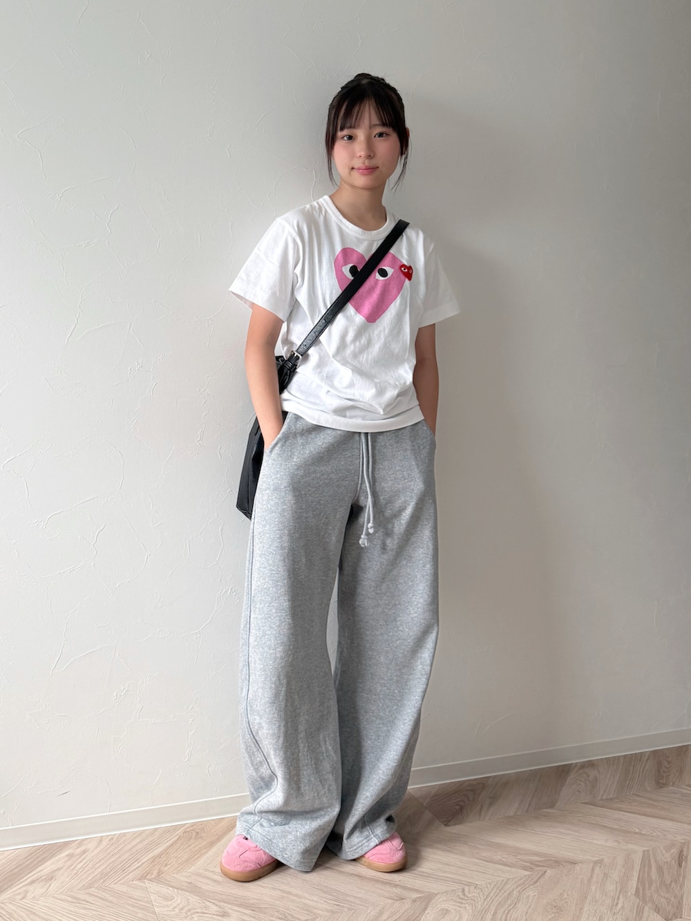 ピンク系のスニーカー、ブラック系のショルダーバッグ、ホワイト系のTシャツ/カットソーを着用したキッズの夏コーディネートの2枚目の写真