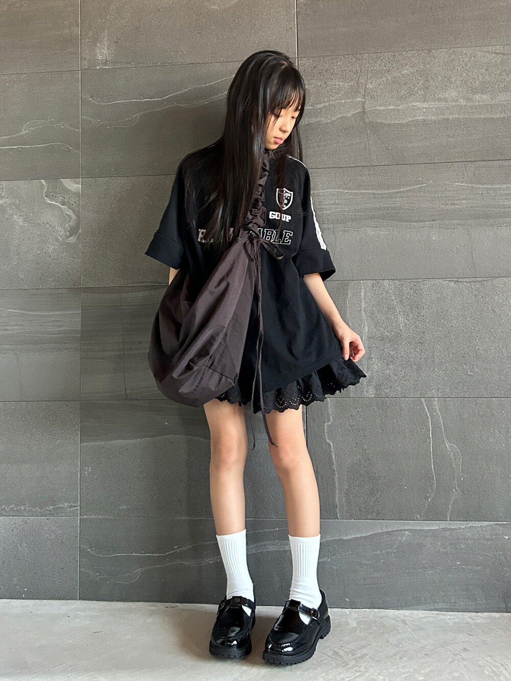 ブラック系のTシャツ/カットソー、ブラック系のスカート、ブラック系のショルダーバッグを着用したキッズの夏コーディネートの3枚目の写真