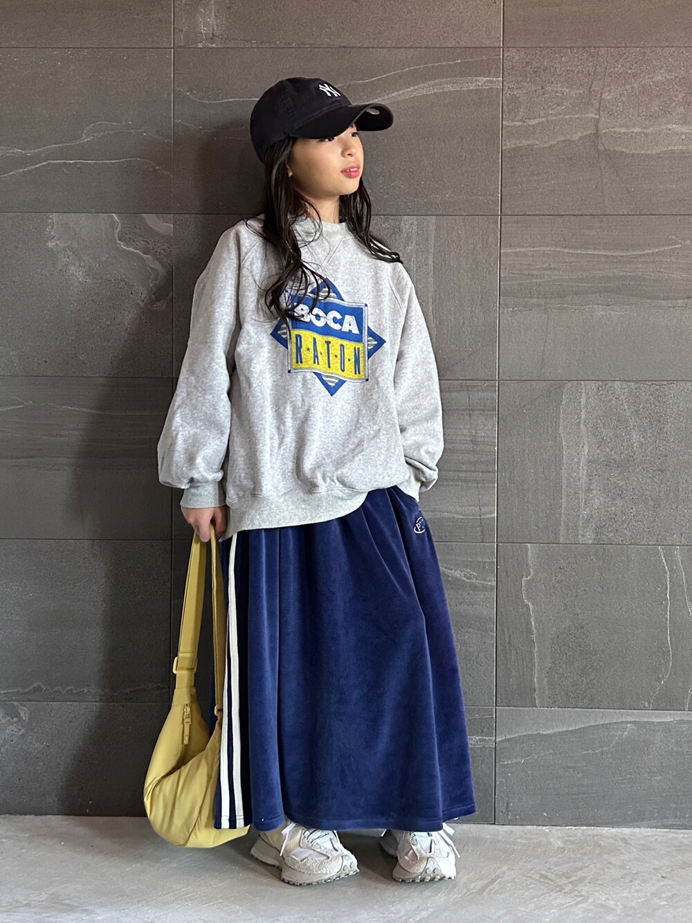 グレー系のスウェット、ブルー系のスカート、ホワイト系のスニーカーを着用したキッズの冬コーディネートの3枚目の写真