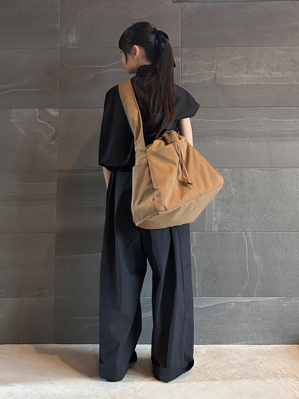 ブラック系のシャツ/ブラウス、ブラック系のパンツ、ブラウン系のショルダーバッグを着用したキッズの春コーディネートの3枚目の写真