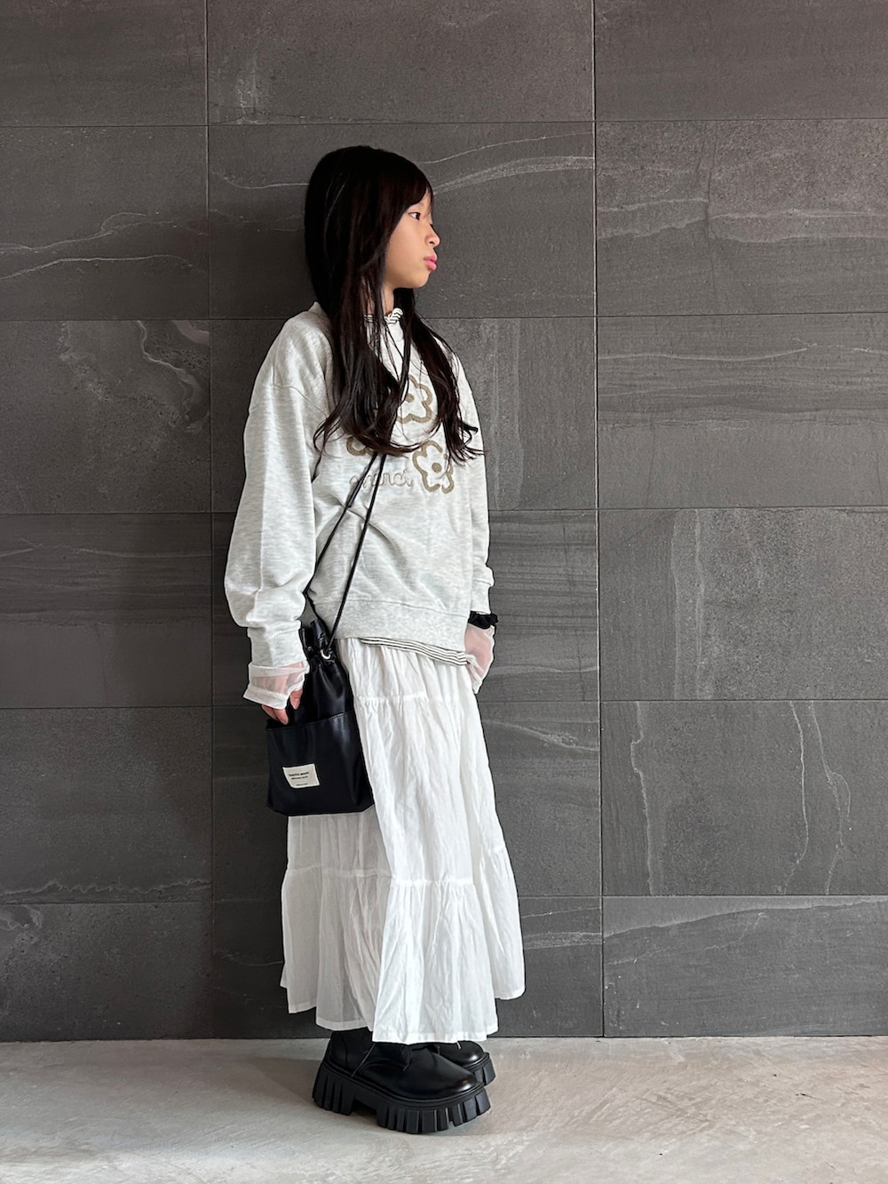 ベージュ系のスウェット、ホワイト系のTシャツ/カットソー、ホワイト系のスカートを着用したキッズの秋コーディネートの3枚目の写真