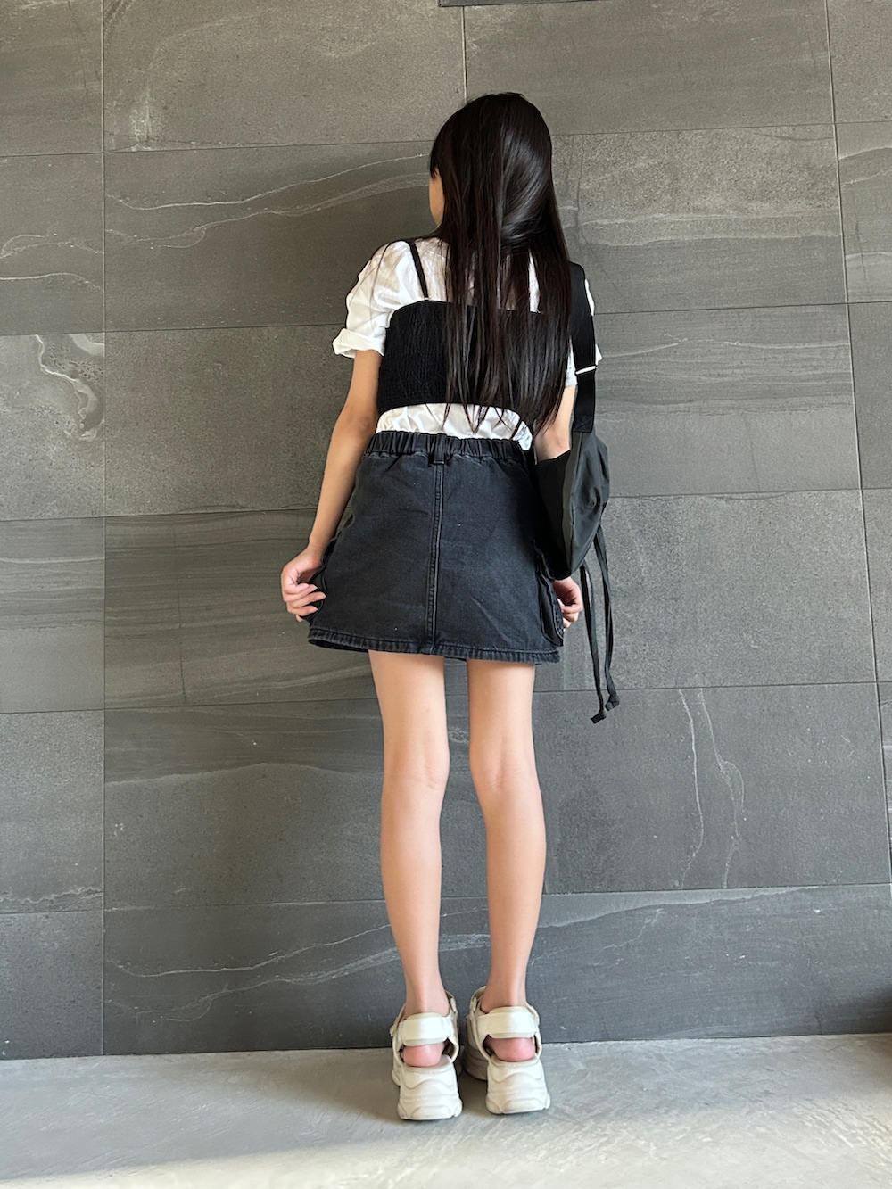 ホワイト系のTシャツ/カットソー、ブラック系のデニムスカート、ブラック系のチューブトップを着用したキッズの夏コーディネートの3枚目の写真