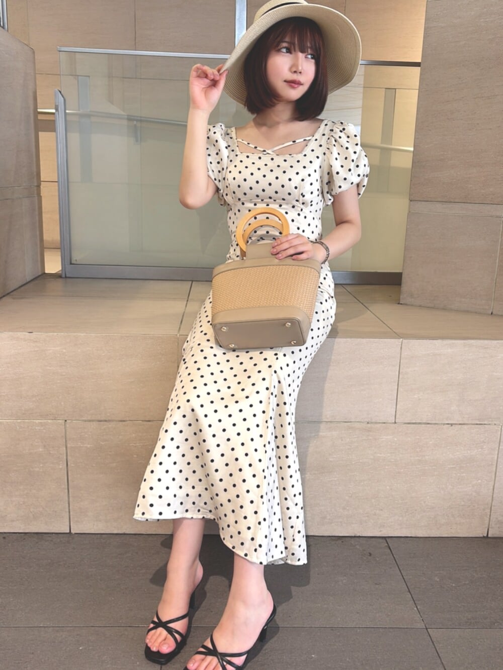 ホワイト系のワンピース、ベージュ系のハンドバッグ、ブラック系のサンダルを着用したレディースの夏コーディネートの6枚目の写真