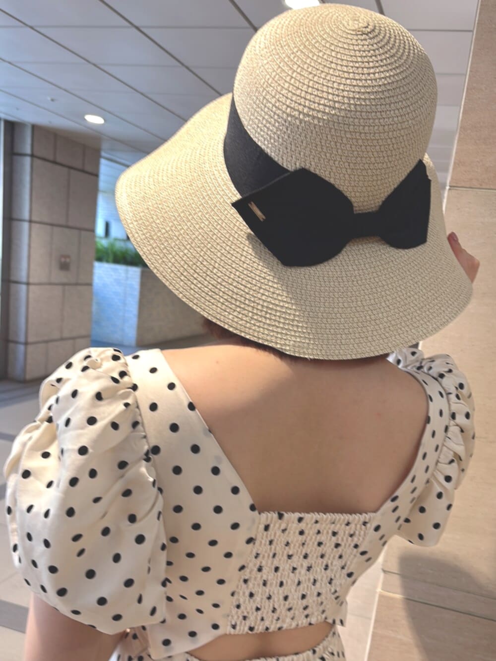ホワイト系のワンピース、ベージュ系のハンドバッグ、ブラック系のサンダルを着用したレディースの夏コーディネートの5枚目の写真