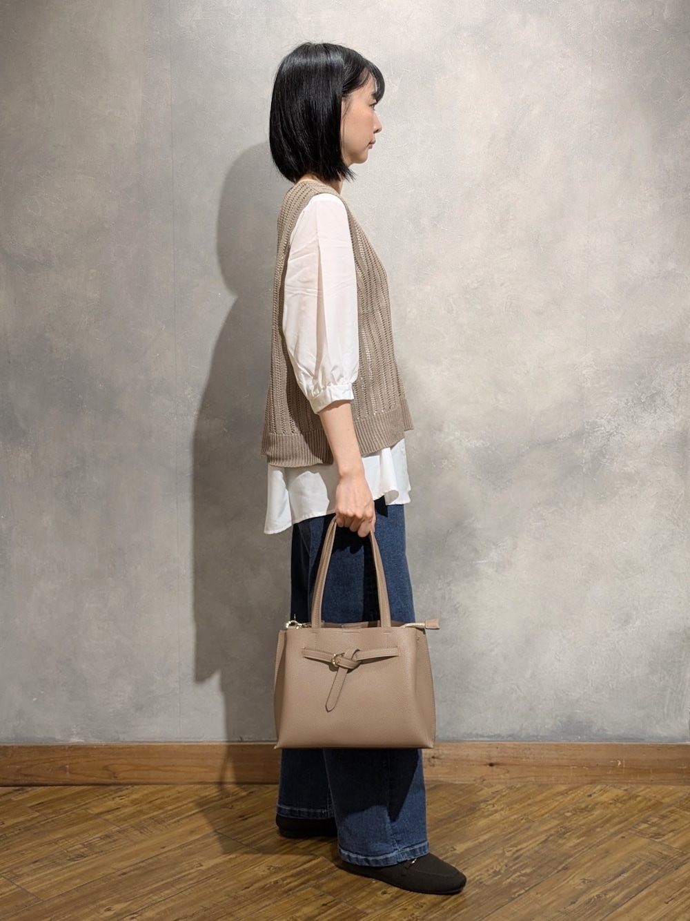ブルー系のデニムパンツ、ブラウン系のその他シューズ、ベージュ系のトートバッグを着用したレディースの夏コーディネートの2枚目の写真