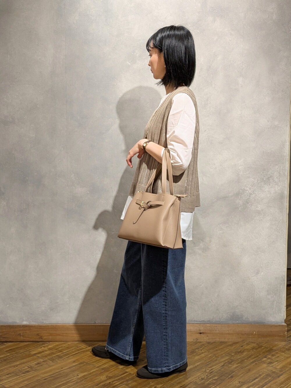 ブルー系のデニムパンツ、ブラウン系のその他シューズ、ベージュ系のトートバッグを着用したレディースの夏コーディネートの3枚目の写真