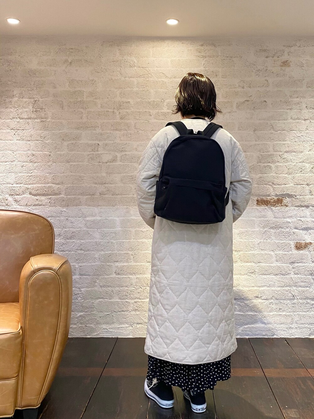 ブラック系のスニーカー、ブラック系のスカート、ベージュ系のその他アウターを着用したレディースの冬コーディネートの4枚目の写真