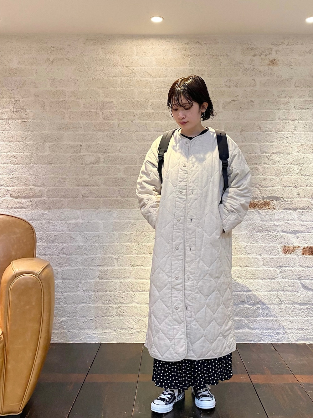 ブラック系のスニーカー、ブラック系のスカート、ベージュ系のその他アウターを着用したレディースの冬コーディネートの3枚目の写真