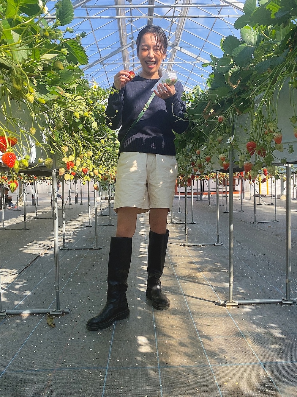 ブルー系のニット/セーター、ベージュ系のその他パンツ、グリーン系のショルダーバッグを着用したレディースの冬コーディネートの2枚目の写真