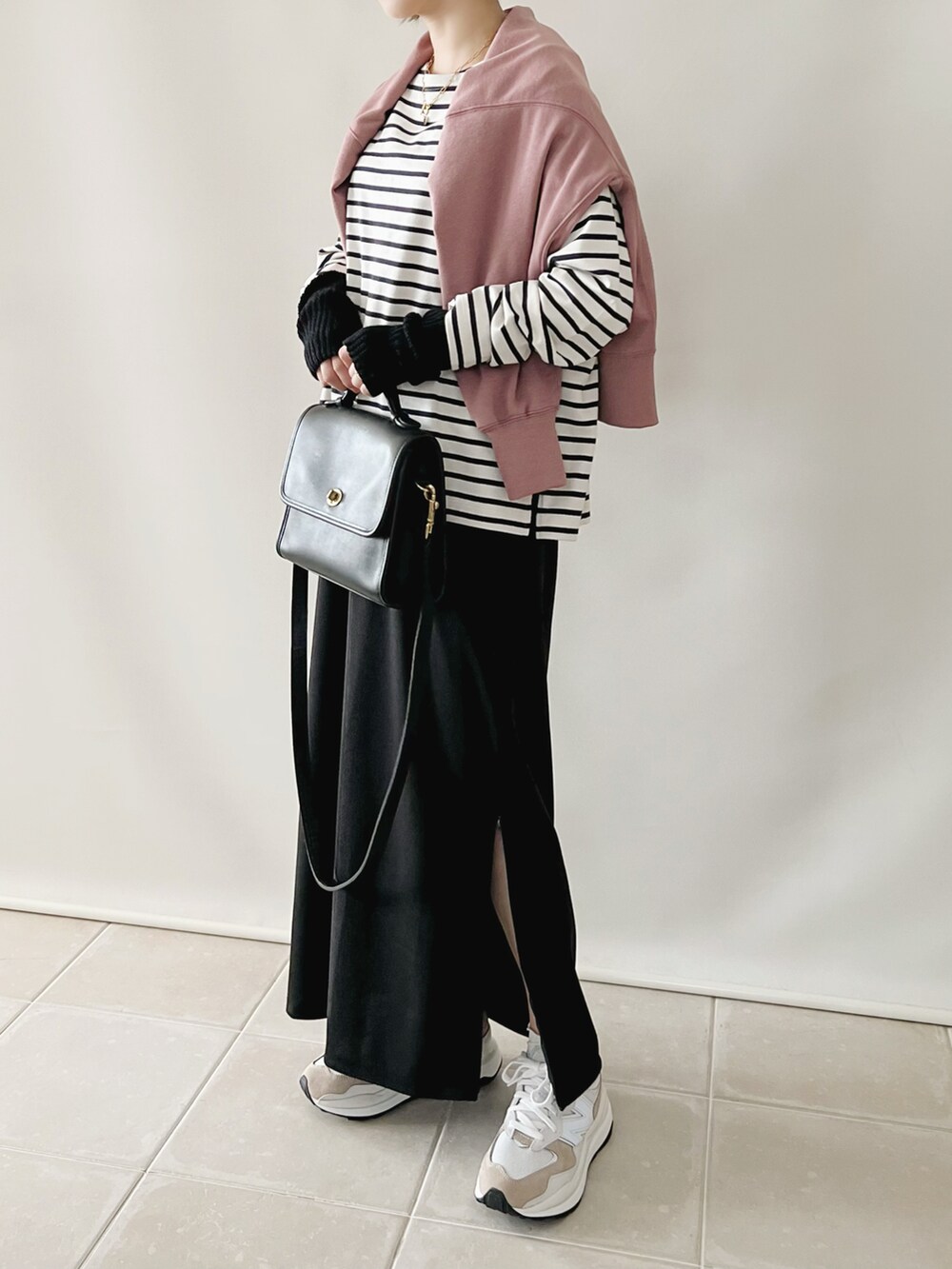 ブラック系のトップス、パープル系のカーディガン/ボレロ、ブラック系のスカートを着用したレディースの秋コーディネートの2枚目の写真