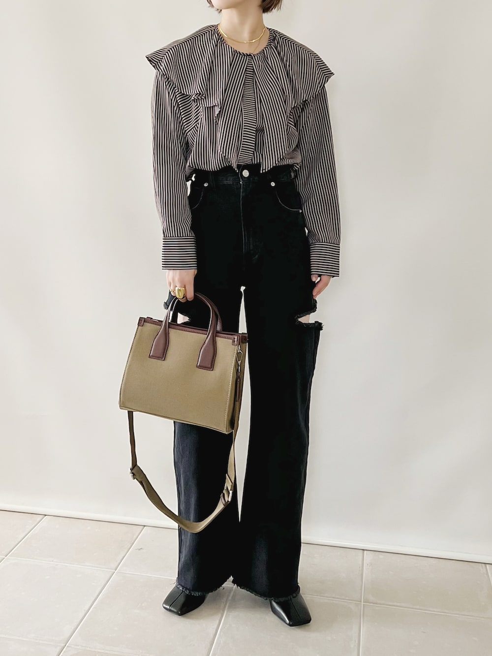 ブルー系のシャツ/ブラウス、ブラック系のデニムパンツ、ベージュ系のバッグを着用したレディースの秋コーディネートの2枚目の写真