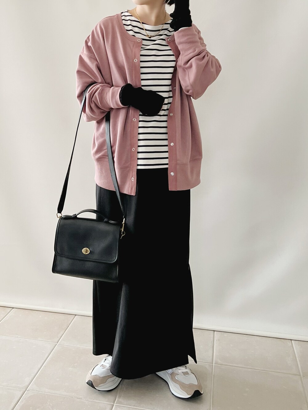 ブラック系のトップス、パープル系のカーディガン/ボレロ、ブラック系のスカートを着用したレディースの秋コーディネートの3枚目の写真