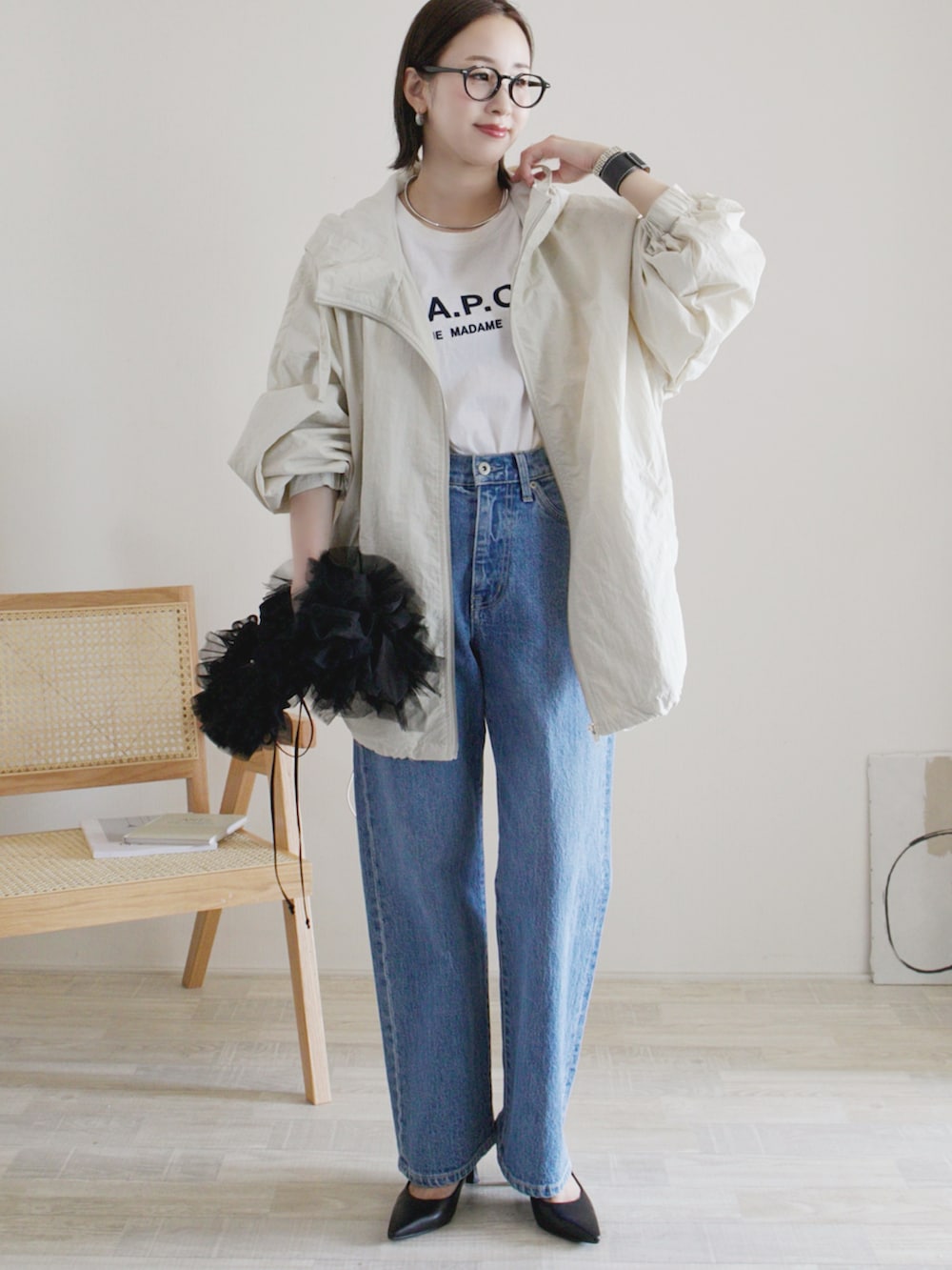 ホワイト系のマウンテンパーカー、ホワイト系のTシャツ/カットソー、ブルー系のデニムパンツを着用したレディースの秋コーディネートの2枚目の写真
