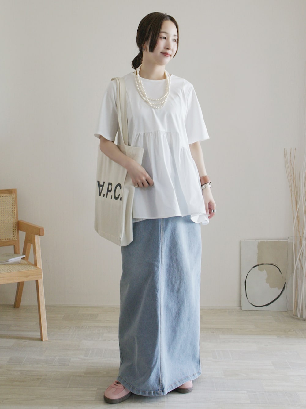 ホワイト系のTシャツ/カットソー、ブルー系のデニムスカート、ピンク系のスニーカーを着用したレディースの春コーディネートの2枚目の写真