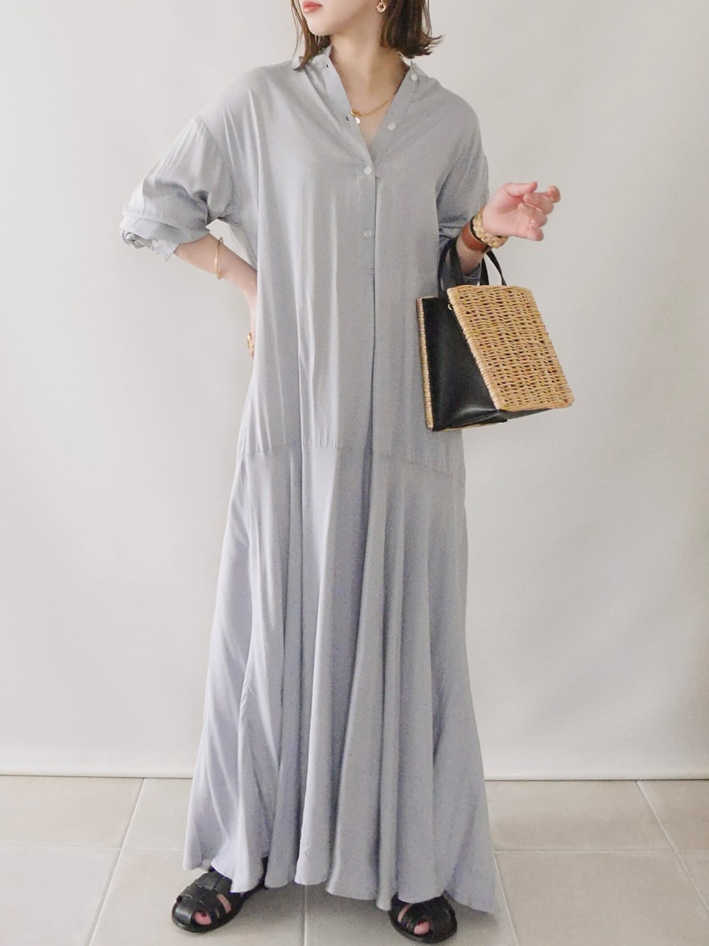 グレー系のシャツワンピース、ホワイト系のトップス、ブラック系のバッグを着用したレディースの春コーディネートの4枚目の写真